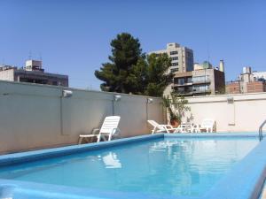 a swimming pool with chairs on a rooftop at Apartamento DELUXE Edificio Millenium in Mendoza