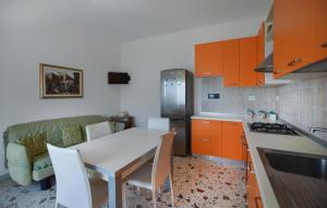 a kitchen with orange cabinets and a white table and chairs at 4 Bedroom Cozy Home In Reggio Calabria in Reggio Calabria +8 photos