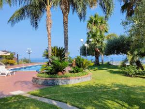 a park with palm trees and a swimming pool at Casa dell'Antico Ulivo 2 by Holiday World in Nunziata