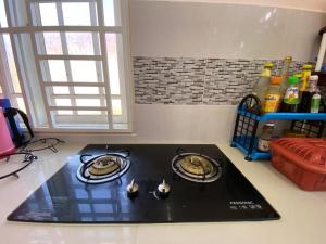a kitchen with a black stove top in a kitchen at Surayahomestay in Bachok