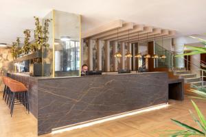 a man sitting at a counter in a room with a lobby at Acta Pirámides in Madrid