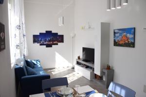 een woonkamer met een blauwe bank en een tv bij La Dimora In Blu in Bologna