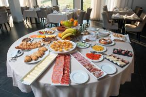 ein Tisch mit einem Buffet mit Speisen drauf in der Unterkunft Hotel Parque Serra da Lousã in Miranda do Corvo