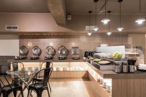 una cucina con bancone, tavolo e sedie di The Riverside Hotel Hengchun a Città Vecchia di Hengchun