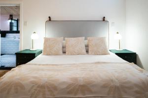 a bedroom with a large bed with two night stands at Casa Caprice - a 3 bed home steps from the beach in Cape Town