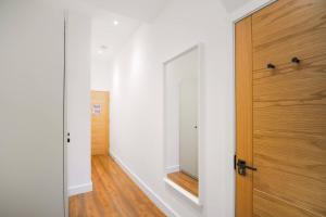 a hallway with a wooden door and a mirror at Afflecks by The Heim Residences in Manchester