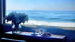 a table with a vase of flowers and a view of the ocean at Copper Beach Villa 2 Umdloti in Umdloti +25 photos