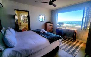 a bedroom with a bed and a view of the ocean at Copper Beach Villa 2 Umdloti in Umdloti