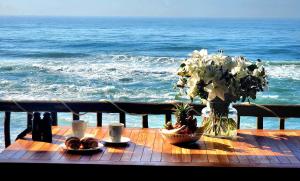 a table with food and flowers on the beach at Copper Beach Villa 2 Umdloti in Umdloti