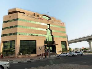 a building with cars parked in front of it at Fortune Plaza Hotel, Dubai Airport in Dubai