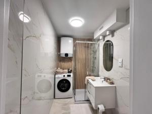 a bathroom with a washing machine and a washer at Prestige Apartment Bohaterów Warszawy in Kielce
