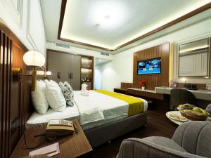 a hotel room with a bed and a television at Fortune Plaza Hotel, Dubai Airport in Dubai