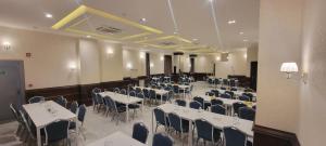 a banquet hall with white tables and blue chairs at Big Ben Hotel Suites in Amman +94 photos