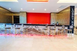 a bar in a hotel lobby with stools at Granada Luxury Red Adult Only in Alanya