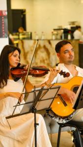 a man and a woman playingviolin and a man holding a guitar at Granada Luxury Red Adult Only in Alanya
