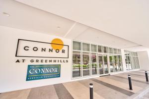 マニラにあるThe Connor Serviced Residences Managed by HIIの緑の地域の彗星を読む看板のある建物