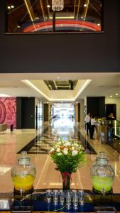a lobby with two vases and flowers on a table at Granada Luxury Red Adult Only in Alanya