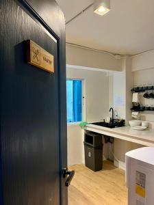 an open door to a kitchen with a sink at The Motuga Hostel Bangkok in Bangkok