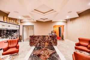 a lobby with a fireplace and two chairs at Granada Luxury Red Adult Only in Alanya