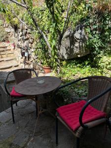 a table with two chairs and a table with a red cushion at Appartement maison de village à Ota-Porto in Porto Ota