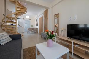 a living room with a vase of flowers on a table at HomEasy Apartments - Kalamata Central Getaways with Private Parking in Kalamata