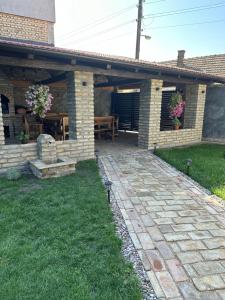 a patio of a house with a table and flowers at Sobe Tanja in Subotica
