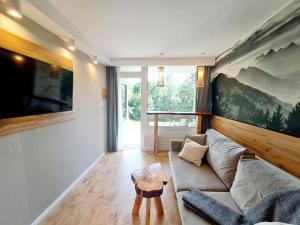 a living room with a couch and a table at Apartament Piętnastka Ustroń in Ustroń