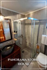 a bathroom with a shower with a sink and a toilet at Panorama Stone Houses - Skadar Lake in Cetinje +11 photos