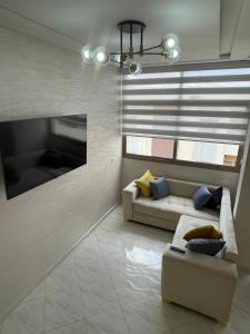 ein Wohnzimmer mit einer Couch und einem Fenster in der Unterkunft Housse Fez City in Fès