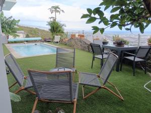 a patio with chairs and a table and a pool at Ti Kaz Gigi in La Possession