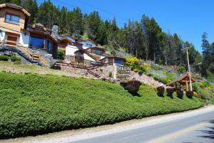 a house on a hill next to a road at Alun Bungalows Apart in San Carlos de Bariloche