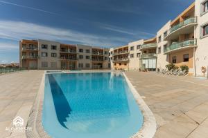 a large swimming pool in the middle of a courtyard at Summer in Paradise - Sea View and Pool in Ericeira in Ericeira