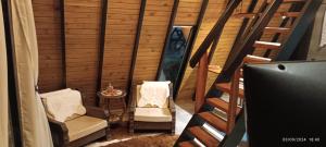 a small room with two chairs and a table at Chalé do lago para casais Fazenda Serramar in Palhoça