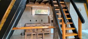 a staircase leading up to a kitchen in a tiny house at Chalé do lago para casais Fazenda Serramar in Palhoça