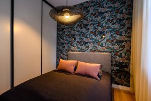 a bedroom with a bed with a wall at Liepaja Apartments Parkside in Liepāja