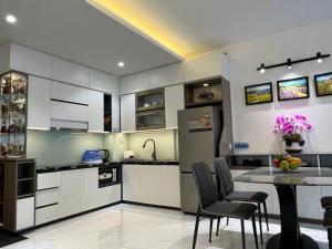 a kitchen with white cabinets and a table with chairs at Dan's house in Kinh Dinh