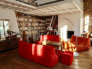 a living room with red furniture and bookshelves at Loft style condo 4 people in central and trendy Paris in Paris
