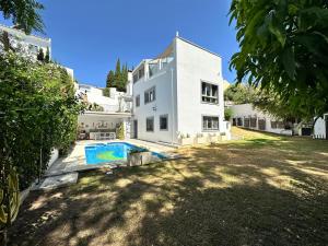 a white house with a swimming pool in the yard at Wonderful private villa near beach with sea views in Marbella