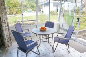 a room with a table and chairs and a bowl of oranges at Sunny garden house in Lenah Valley