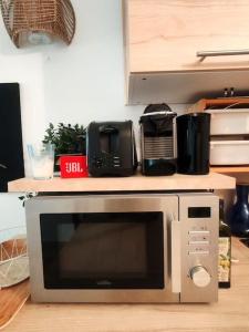 a microwave sitting on top of a counter at Le Sunshine - 2 people studio & Todler - Cosy - Porte des Lilas in Les Lilas +4 photos
