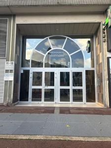 a store front with a large glass door on a street at Le Sunshine - 2 people studio & Todler - Cosy - Porte des Lilas in Les Lilas