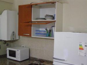 cocina con microondas blanco y nevera en Apartamento Edificio Atlantis I en Villa Carlos Paz
