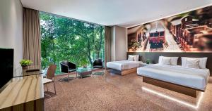 a bedroom with two beds and a large window at FM7 Resort Hotel - Jakarta Airport in Tangerang