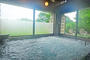 a swimming pool in a house with glass windows at 森のオーベルジュ 三 みつ - 旧 森厚真hotel CHUPKI - in Chitose