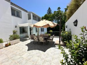 a patio with a table and an umbrella at Wonderful private villa near beach with sea views in Marbella