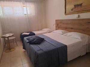 a hotel room with two beds and a table at Hotel Signorini in Castiglioncello