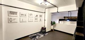 a room with a white wall with pictures on it at 2Sleep DMK Airport Bangkok in Ban Ko