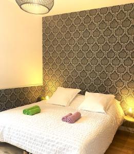 a bedroom with a bed with two slippers on it at CH1- MANOIR DU MOULINIER - Campagne - Calme - Petit-déj inclus - Table d'hôte sur réservation - Parking gratuit in La Limouzinière