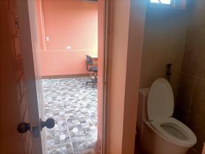 a bathroom with a toilet and a chair in a room at Colorado Dos, Jubay Liloan Cebu in Cotcot +10 photos
