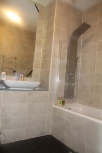 a bathroom with a sink and a bath tub at Flat 414 One bedroom apartment in Birmingham +8 photos